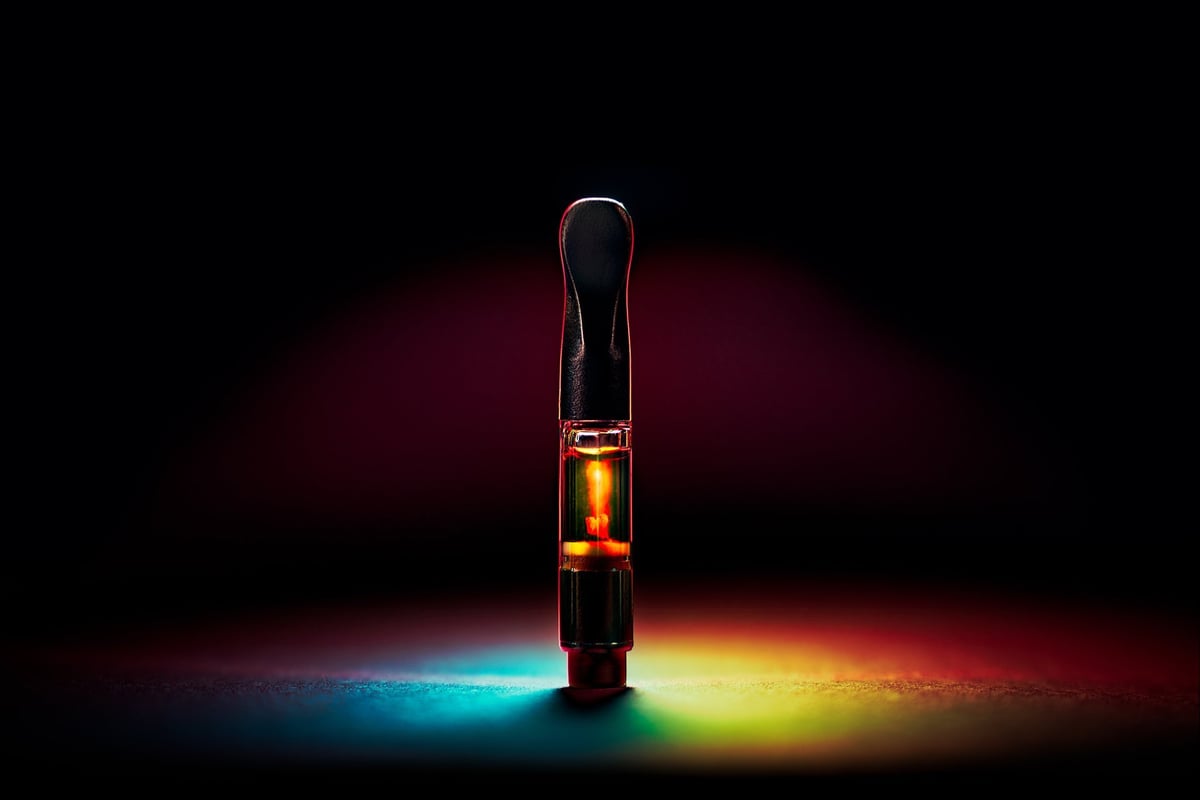 Premium hemp-derived vape cartridge with rainbow lighting on dark background